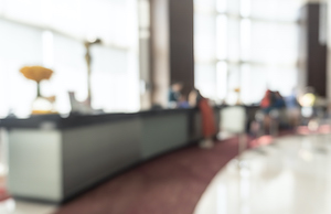 Concierge service blur background reception counter of hotel, restaurant or apartment's front desk in luxury reception hall with staff working for serving tourist guest or check-in customers
